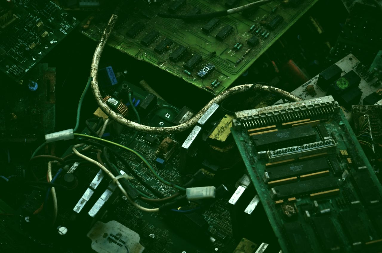 The meme is a photo of a computer motherboard with wires and components severely damaged by water, likely due to a flood or other water-related disaster. The image is captioned "When you're trying to save your gaming PC but it's just too salty".